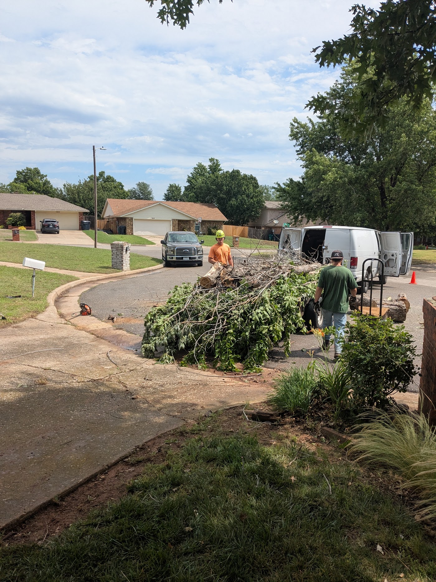 Prairie Wind crew clearing cut limbs from a Norman driveway